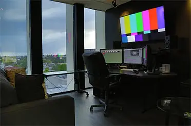 office chair and three monitors on a table by the window